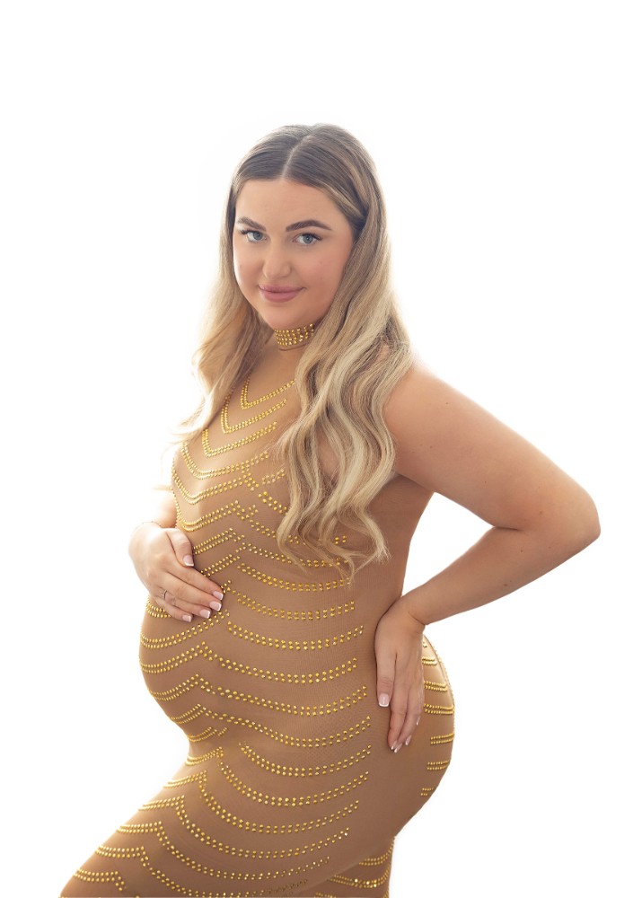 Pregnant woman in gold-accented gown, a glamorous moment from an Essex maternity session
