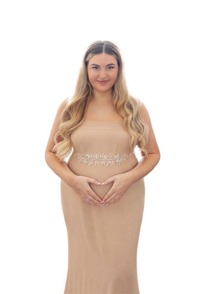 Mother-to-be glowing in a tan gown with intricate beading, a serene Essex pregnancy portrait.