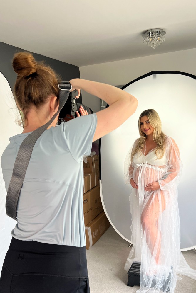 Mother-to-be in sheer maternity gown posing for a professional studio photoshoot in Chelmsford