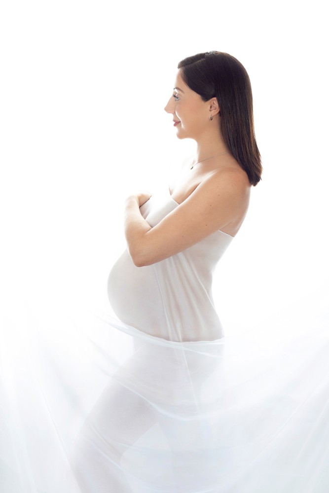 Elegant Essex pregnancy portrait session with creative lighting and outfit details