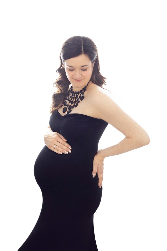 Classic maternity portrait with a black gown and intricate necklace in Colchester, Essex