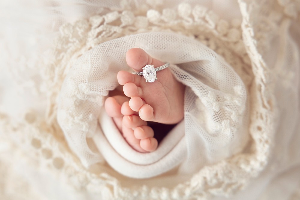 Close-up of newborn toes with sparkling diamond ring, professional Essex baby photography