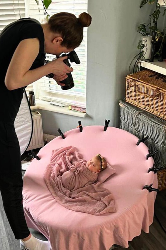 Photographer capturing a serene newborn moment in Chelmsford, Essex, featuring soft pink tones and a floral crown